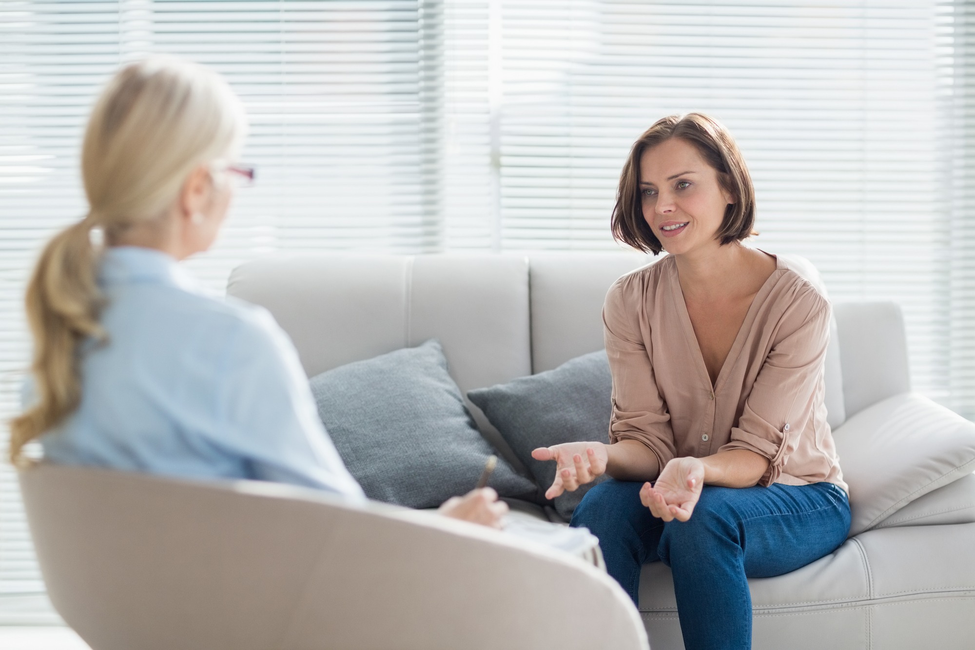 Woman Talking To Therapist on Sofa at Home